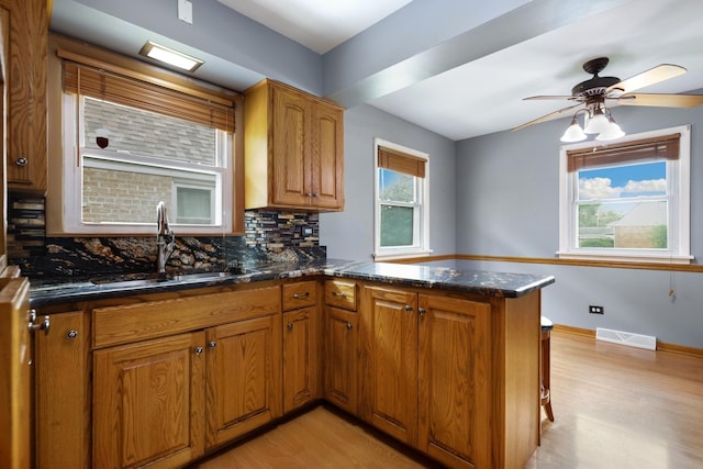 17708 Walter St, Lansing, IL 60438 - kitchen featuring light wood finished floors, a sink, backsplash, and brown cabinetry