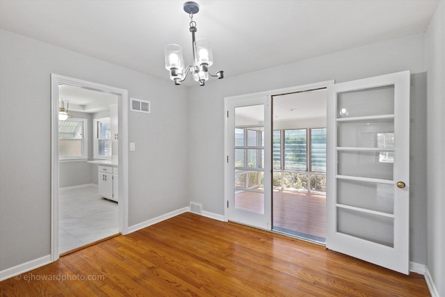 5049 Birchwood Ave, Skokie, IL 60077 - unfurnished dining area featuring a chandelier, wood finished floors, and baseboards