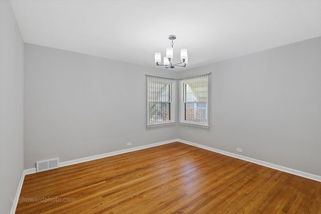 5049 Birchwood Ave, Skokie, IL 60077 - empty room featuring a chandelier, baseboards, and wood finished floors