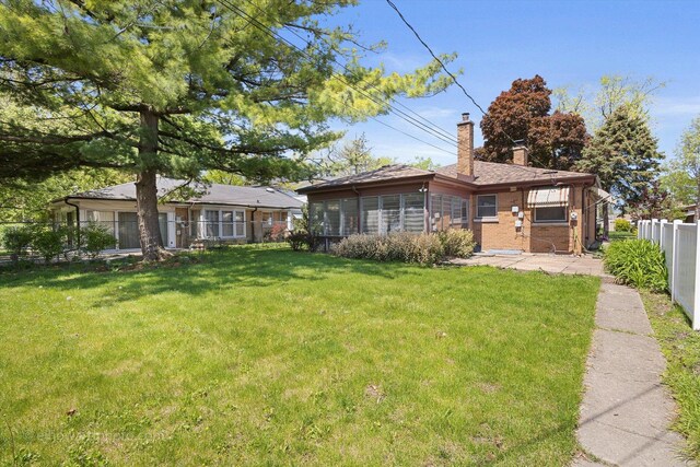 5049 Birchwood Ave, Skokie, IL 60077 - view of front facade featuring a chimney, brick siding, and a sunroom