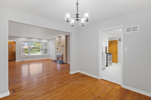 5049 Birchwood Ave, Skokie, IL 60077 - unfurnished living room featuring a chandelier, light wood-style flooring, baseboards, and a brick fireplace