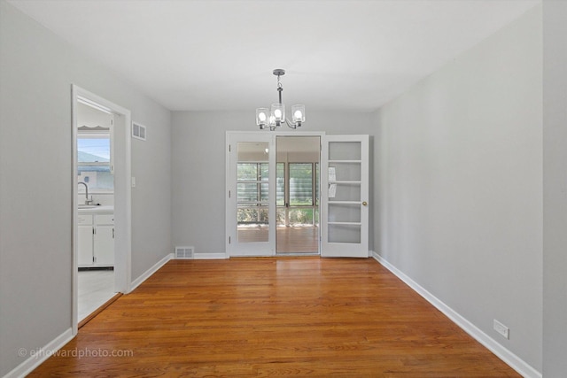 5049 Birchwood Ave, Skokie, IL 60077 - unfurnished dining area featuring a chandelier, light wood-style flooring, baseboards, and a sink