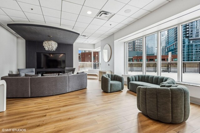512 N Mcclurg Ct Unit 902, Chicago, IL 60611 - living room featuring wood finished floors, a chandelier, and a drop ceiling