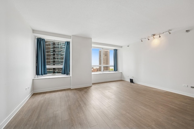 512 N Mcclurg Ct Unit 902, Chicago, IL 60611 - spare room featuring wood finished floors, track lighting, and baseboards