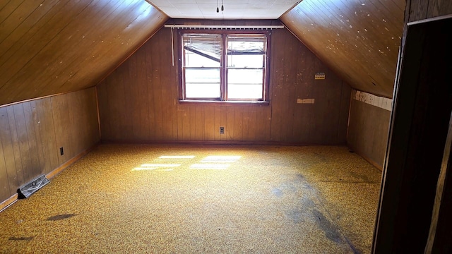 additional living space featuring carpet flooring, wood walls, and vaulted ceiling