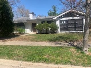 view of front of property featuring a chimney and a garage