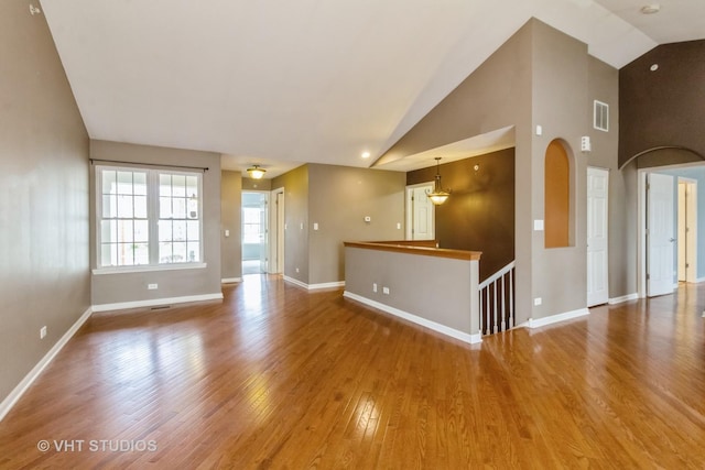19 Tall Grass Ct, Streamwood, IL 60107 - empty room featuring wood finished floors, baseboards, high vaulted ceiling, and arched walkways