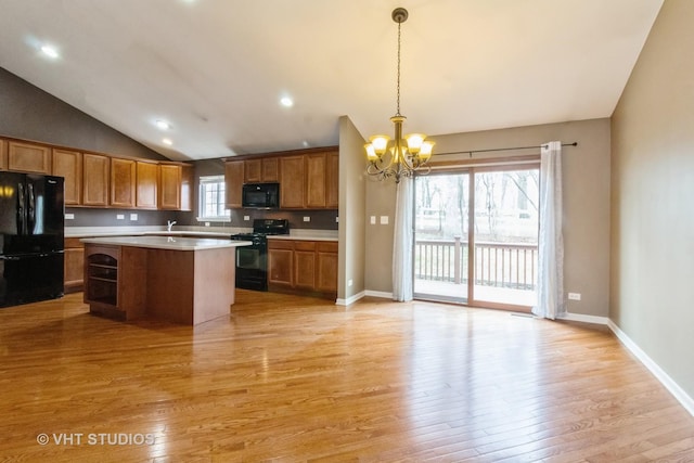 19 Tall Grass Ct, Streamwood, IL 60107 - kitchen featuring black appliances, a chandelier, light wood-style flooring, light countertops, and vaulted ceiling