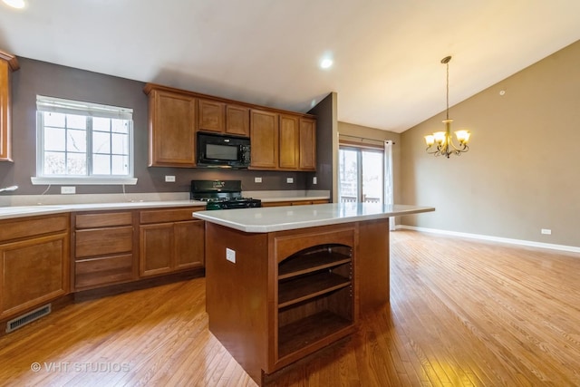 19 Tall Grass Ct, Streamwood, IL 60107 - kitchen with black microwave, range with gas stovetop, brown cabinetry, light wood-style flooring, and vaulted ceiling