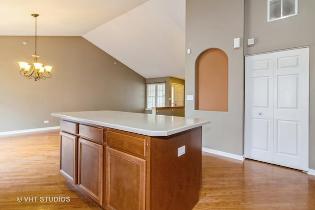 19 Tall Grass Ct, Streamwood, IL 60107 - kitchen with light wood finished floors, a chandelier, hanging light fixtures, a center island, and vaulted ceiling