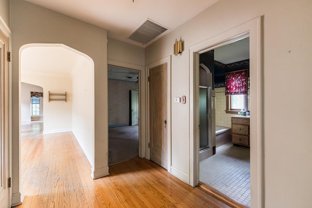 1753 N Normandy Ave, Chicago, IL 60707 - hallway with light wood-style floors, arched walkways, and baseboards