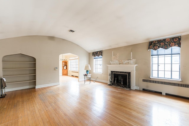 1753 N Normandy Ave, Chicago, IL 60707 - living area with radiator heating unit, light wood-type flooring, arched walkways, baseboards, and a high end fireplace