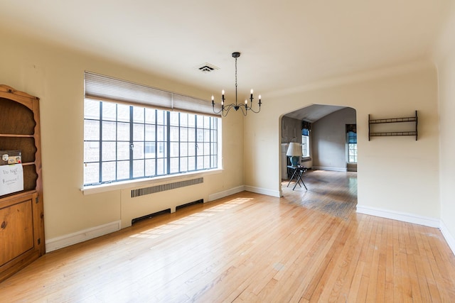 1753 N Normandy Ave, Chicago, IL 60707 - unfurnished dining area featuring radiator, a chandelier, arched walkways, hardwood / wood-style flooring, and baseboards