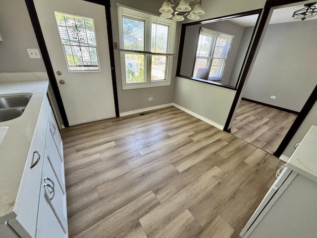 20084 Brook Ave, Lynwood, IL 60411 - unfurnished dining area with a chandelier, light wood-style floors, and baseboards