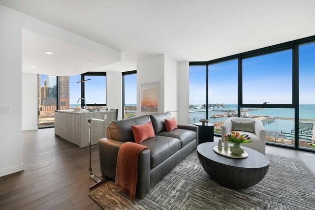 211 N Harbor Dr Unit 2208, Chicago, IL 60601 - living area featuring expansive windows, dark wood-style flooring, plenty of natural light, and a water view