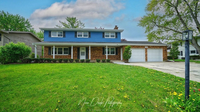 traditional-style home featuring a garage, a chimney, concrete driveway, a front lawn, and brick siding