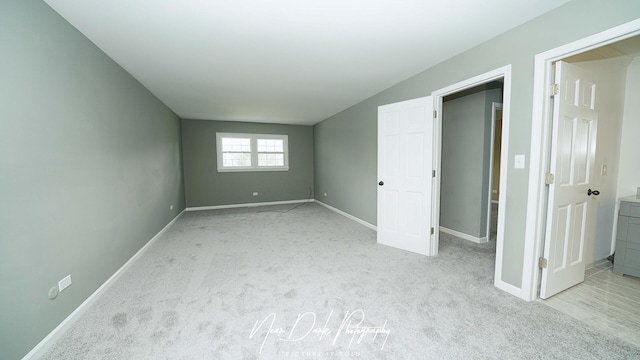 unfurnished bedroom featuring light carpet and baseboards