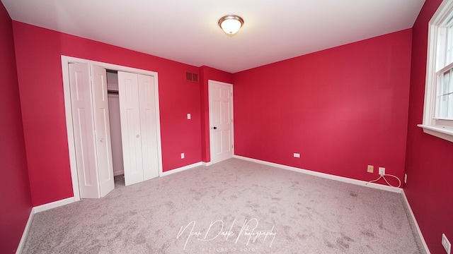unfurnished bedroom with carpet floors, baseboards, and a closet