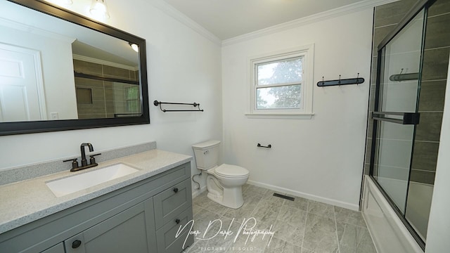 full bath featuring crown molding, vanity, toilet, baseboards, and combined bath / shower with glass door