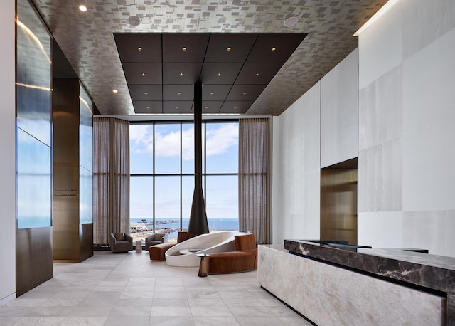 common area with floor to ceiling windows, a high ceiling, and recessed lighting