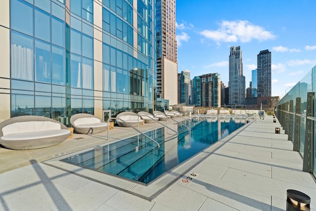 community pool with a view of skyline and a patio area