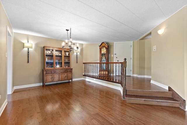 13151 S Westview Dr Unit 1B, Palos Heights, IL 60463 - empty room featuring a chandelier, wood finished floors, baseboards, and a textured ceiling