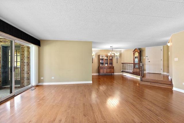 13151 S Westview Dr Unit 1B, Palos Heights, IL 60463 - unfurnished living room featuring a chandelier, wood finished floors, a textured ceiling, and baseboards