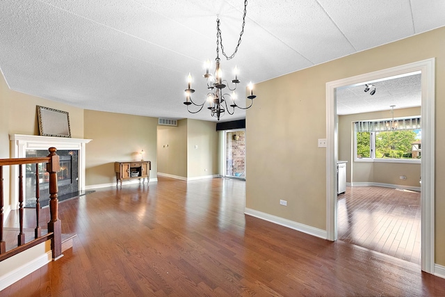 13151 S Westview Dr Unit 1B, Palos Heights, IL 60463 - unfurnished room with a chandelier, dark wood finished floors, a fireplace, a textured ceiling, and baseboards