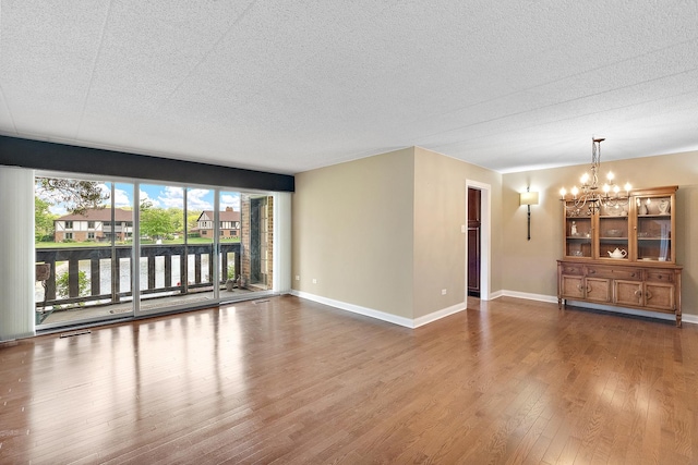 13151 S Westview Dr Unit 1B, Palos Heights, IL 60463 - unfurnished living room with a chandelier, wood finished floors, baseboards, a textured ceiling, and a water view