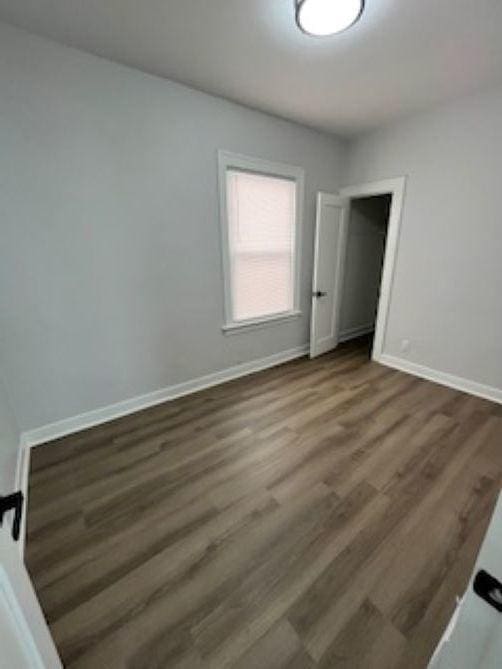 unfurnished bedroom featuring baseboards and wood finished floors