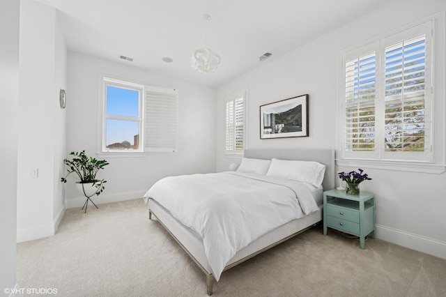 bedroom with light colored carpet, multiple windows, and baseboards