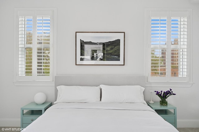bedroom with baseboards and multiple windows