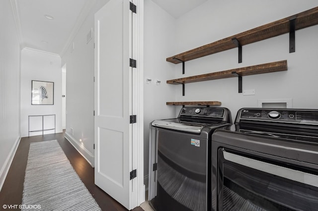 laundry room featuring separate washer and dryer, dark wood-type flooring, crown molding, and baseboards