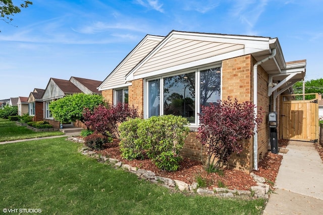 view of home's exterior with a lawn and brick siding