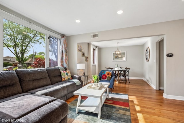 living area featuring baseboards, healthy amount of natural light, light wood-style floors, and recessed lighting