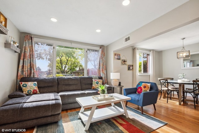 living area with wood finished floors, a chandelier, and recessed lighting