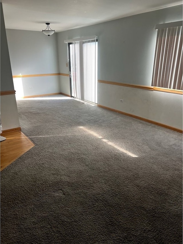 empty room featuring carpet and baseboards