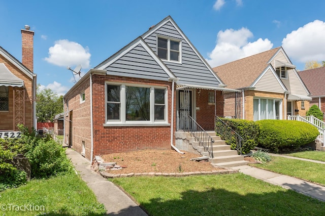 bungalow-style house featuring brick siding and a front lawn