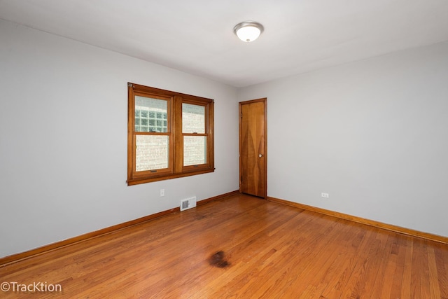 empty room with baseboards and light wood-type flooring