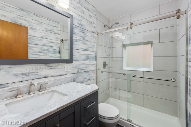 bathroom featuring a shower stall, toilet, and vanity