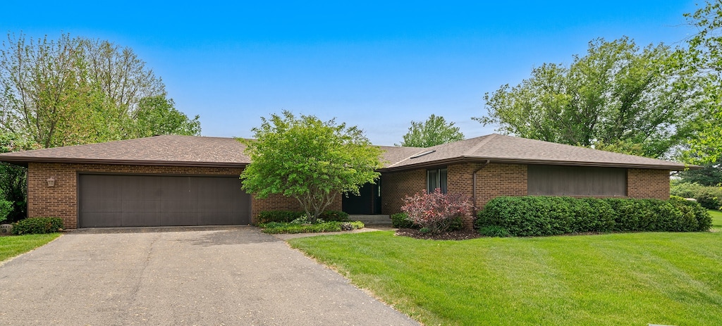 7298 Vista, Stillman Valley, IL 61084 - view of front of house featuring brick siding, driveway, a garage, and a front lawn