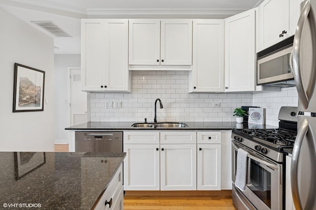 2700 N Halsted St Unit 406, Chicago, IL 60614 - kitchen featuring appliances with stainless steel finishes, a sink, backsplash, and white cabinets