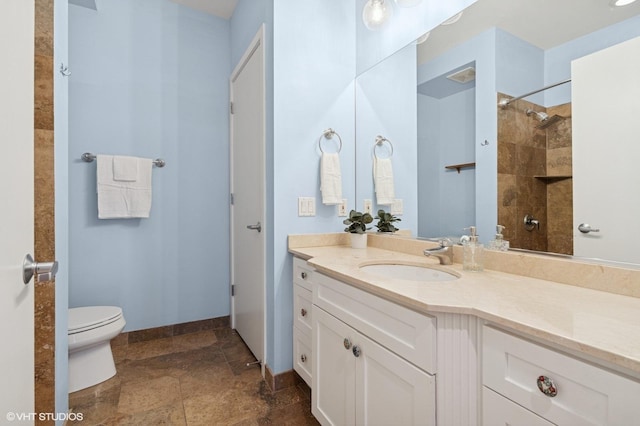 2700 N Halsted St Unit 406, Chicago, IL 60614 - full bathroom with vanity, toilet, stone tile floors, a shower, and baseboards