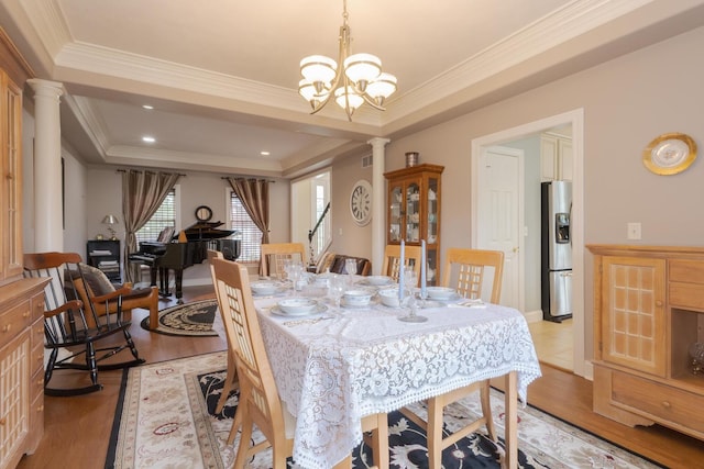6 Conway Cir, Bloomington, IL 61704 - dining space with ornate columns, light wood-type flooring, ornamental molding, a chandelier, and a raised ceiling