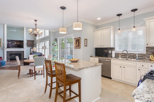 6 Conway Cir, Bloomington, IL 61704 - kitchen with a sink, stainless steel dishwasher, backsplash, a premium fireplace, and light stone counters