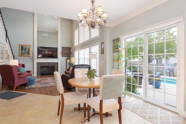 6 Conway Cir, Bloomington, IL 61704 - tiled dining space featuring healthy amount of natural light, a glass covered fireplace, ornamental molding, a chandelier, and a high ceiling