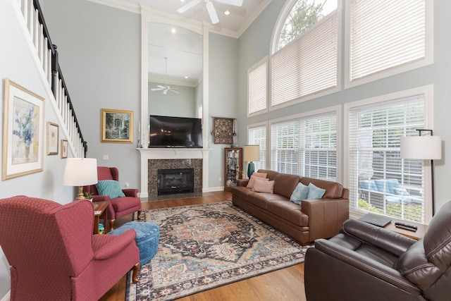 6 Conway Cir, Bloomington, IL 61704 - living room featuring ceiling fan, wood finished floors, a towering ceiling, crown molding, and a premium fireplace