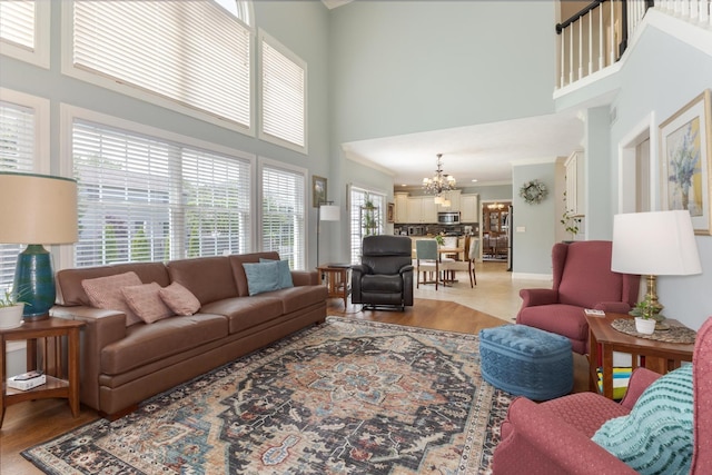 6 Conway Cir, Bloomington, IL 61704 - living room featuring a high ceiling, a chandelier, light wood finished floors, baseboards, and ornamental molding