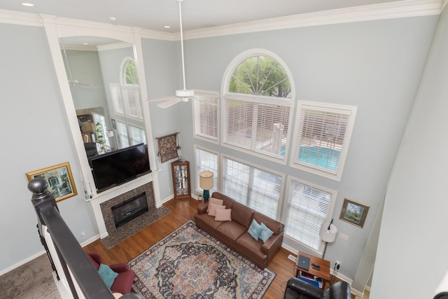 6 Conway Cir, Bloomington, IL 61704 - living area with ceiling fan, a towering ceiling, a fireplace, crown molding, and baseboards