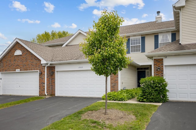 1985 Blackberry Ln Unit 1985, Hoffman Estates, IL 60169 - view of front of house featuring brick siding, driveway, a shingled roof, and a chimney